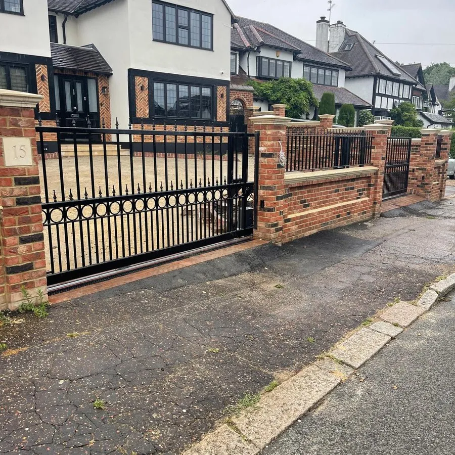 Driveway gates in Harlow with matching railings between brick piers