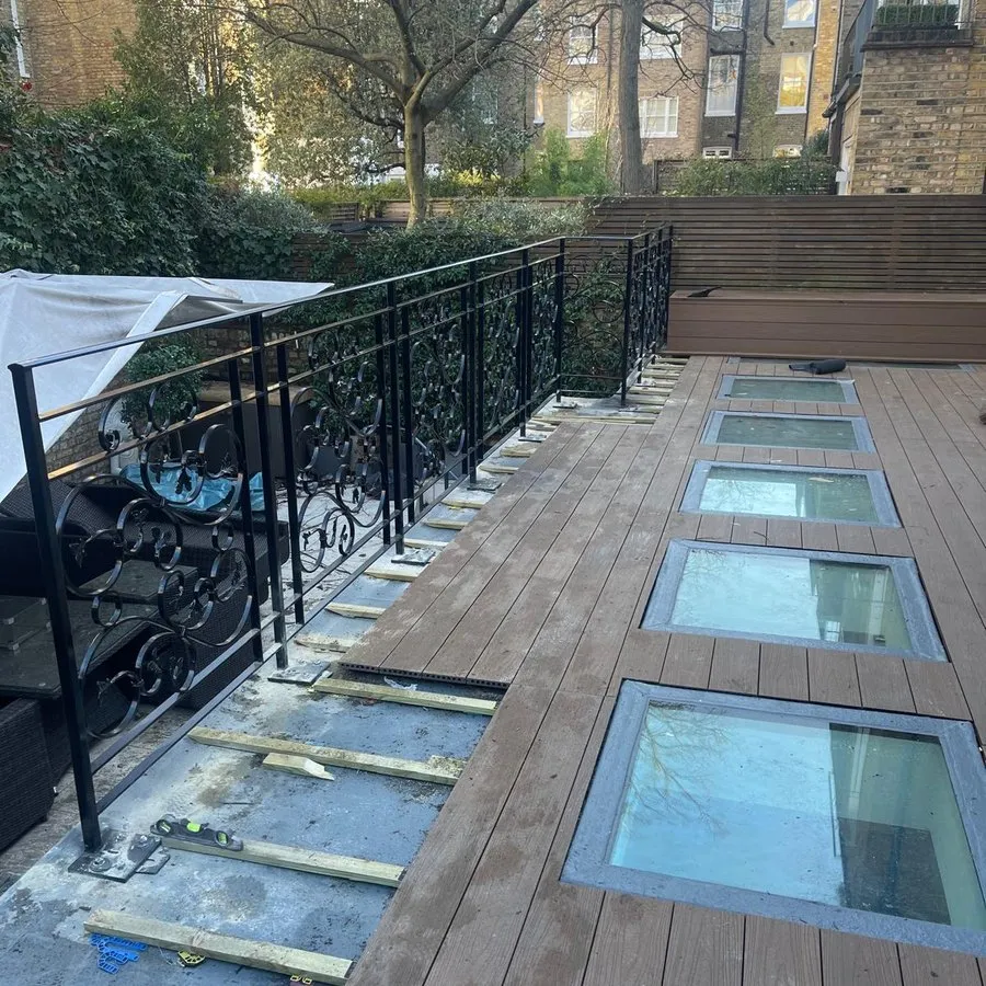 Metal railings in Harlow running alongside a decked terrace with rooflights