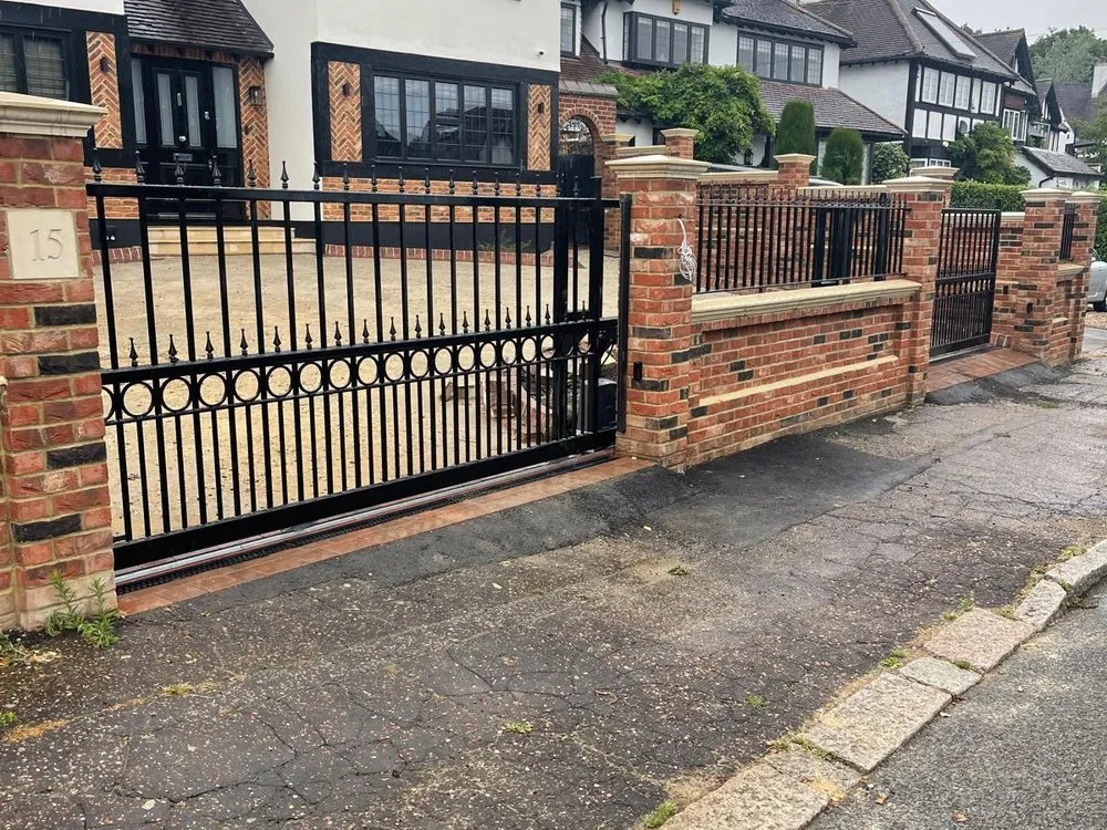 Black driveway gates and railings to a detached property