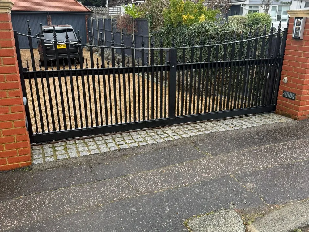 Automated gates closed across a block paved driveway