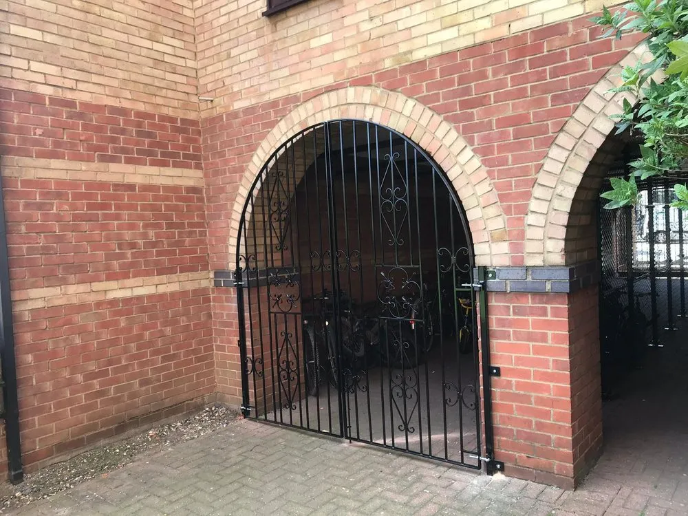 Arched wrought iron gate set into brickwork