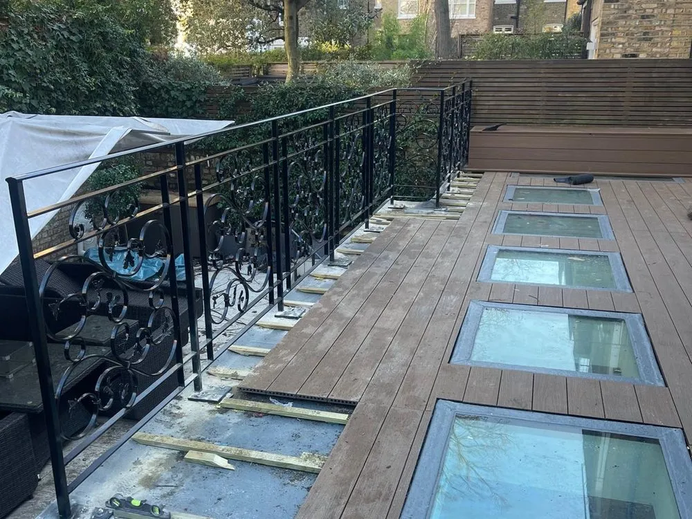 Railings alongside a decked terrace with rooflights