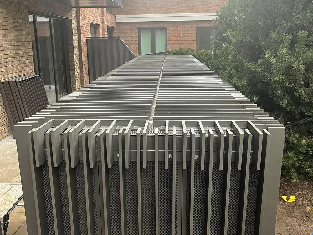 Louvred metal screen enclosing plant at a development